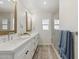 Bright bathroom featuring a double vanity with quartz countertops, framed mirrors, and a glass walk-in shower at 5412 E Tierra Buena Ln, Scottsdale, AZ 85254