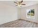 Bright bedroom with wood-look floors, a ceiling fan, and a view to the outside at 5412 E Tierra Buena Ln, Scottsdale, AZ 85254