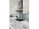 Close-up of a modern kitchen featuring white cabinetry, stainless steel appliances, and sleek countertops at 5412 E Tierra Buena Ln, Scottsdale, AZ 85254