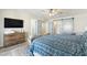 Well-lit main bedroom with barn door closet, wood-look floors, and a wall-mounted television at 5412 E Tierra Buena Ln, Scottsdale, AZ 85254