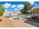 Private pool with an outdoor seating area, lush landscaping, shade umbrellas, and mature trees at 5412 E Tierra Buena Ln, Scottsdale, AZ 85254