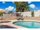 Private pool surrounded by desert landscaping, lounge seating, shade umbrellas, and mature trees at 5412 E Tierra Buena Ln, Scottsdale, AZ 85254