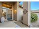 Charming front entrance featuring a decorative metal accent, a stylish light fixture, and lush landscaping at 5742 S Creosote Dr, Gold Canyon, AZ 85118