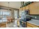 Sunlit kitchen with wooden cabinetry, stainless steel appliances, breakfast nook, and tile flooring at 5742 S Creosote Dr, Gold Canyon, AZ 85118