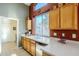 Cozy kitchen features wooden cabinets, stainless dishwasher and sink, complemented by a light countertop at 5742 S Creosote Dr, Gold Canyon, AZ 85118