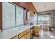 Bright kitchen featuring a garden window, wood cabinetry, and a stainless steel dishwasher at 5742 S Creosote Dr, Gold Canyon, AZ 85118