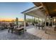 Beautiful covered patio with a seating area and views of the golf course at sunset at 5742 S Creosote Dr, Gold Canyon, AZ 85118