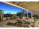 Covered outdoor patio area, featuring desert landscaping and a golf course view at 5742 S Creosote Dr, Gold Canyon, AZ 85118