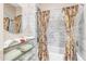 Modern bathroom with stylish tile surround, glass shelving, and a shower with decorative curtains at 616 E Carver Rd, Tempe, AZ 85284