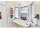 Elegant bathroom features a clawfoot tub, chandelier, and charming built-in shelving at 616 E Carver Rd, Tempe, AZ 85284