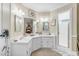 Bright bathroom with dual sinks, white cabinetry, and a glass-enclosed shower at 616 E Carver Rd, Tempe, AZ 85284