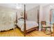 Bedroom with striped wallpaper, a four-poster bed, and a carved wardrobe at 616 E Carver Rd, Tempe, AZ 85284