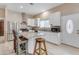 Well-lit kitchen with stainless steel appliances, white cabinets, and a granite countertop island with chairs at 616 E Carver Rd, Tempe, AZ 85284