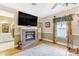 Living room with hardwood floors, fireplace, and modern wall mounted tv, plus detailed trim throughout at 616 E Carver Rd, Tempe, AZ 85284