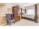 Spacious main bedroom featuring a decorative wooden bed frame, matching wardrobe, and an upholstered chair at 616 E Carver Rd, Tempe, AZ 85284