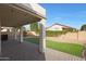 Covered patio with brick pavers overlooks a backyard with artificial grass and desert landscaping at 6516 W Matilda Ln, Glendale, AZ 85308