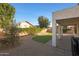 Backyard featuring a covered patio, artificial grass, and easy-care desert landscaping at 6516 W Matilda Ln, Glendale, AZ 85308