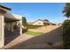 Backyard featuring a covered patio, artificial grass, and desert landscaping at 6516 W Matilda Ln, Glendale, AZ 85308