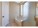 Bathroom featuring a shower, a tub with a glass block window, and a white door at 6516 W Matilda Ln, Glendale, AZ 85308