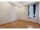 Bright bedroom with wood floor, ceiling fan, and window with dark blue curtains at 6516 W Matilda Ln, Glendale, AZ 85308