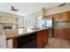 Open kitchen with granite island, stainless sink, adjacent to living area with fireplace at 6516 W Matilda Ln, Glendale, AZ 85308