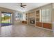 Spacious living room with a ceiling fan, built-in shelving, a fireplace and sliding glass doors at 6516 W Matilda Ln, Glendale, AZ 85308