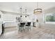 Well-lit, all-white kitchen with a center island, pendant lighting, and backyard views at 7318 W Paso Trl, Peoria, AZ 85383