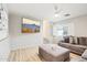 Bright living room with wood floors, plush sofa, ottoman, and wall-mounted television at 7318 W Paso Trl, Peoria, AZ 85383