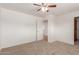 Spacious bedroom with carpet, ceiling fan, and a door leading to the kitchen at 7539 N 50Th Ave, Glendale, AZ 85301