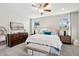 Bright main bedroom with a plush bed, two windows, and stylish dark wood dresser at 7924 S 24Th Pl, Phoenix, AZ 85042