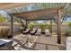 Relaxing backyard patio with pergola, cushioned seating, and elegant brick pavers creates a backyard retreat at 7924 S 24Th Pl, Phoenix, AZ 85042