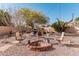 Charming backyard with a fire pit, barbecue grill, and mature desert landscaping at 80 S Maple Ct, Chandler, AZ 85226