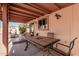 Relaxing covered patio featuring a dining table, seating, and a view of the lush backyard at 80 S Maple Ct, Chandler, AZ 85226