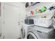 Functional laundry room with washer, dryer, storage shelves, and a white door at 80 S Maple Ct, Chandler, AZ 85226