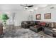 Bright living room with gray walls, modern ceiling fan, decorative area rug and comfortable leather sectional at 80 S Maple Ct, Chandler, AZ 85226