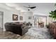 Bright living room with open dining area, modern ceiling fan, decorative area rug and comfortable leather sectional at 80 S Maple Ct, Chandler, AZ 85226