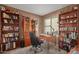 Cozy home office space with bookshelves, a desk, and a view to the outdoors at 80 S Maple Ct, Chandler, AZ 85226