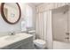 Bright bathroom with a framed mirror, vanity, toilet, and shower-tub combination at 8233 E Calypso Ave, Mesa, AZ 85208