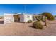 Wide angle shot of the rear exterior of the home with desert landscaping at 8233 E Calypso Ave, Mesa, AZ 85208