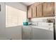 Laundry room featuring a washer and dryer and upper cabinets at 8233 E Calypso Ave, Mesa, AZ 85208