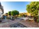 Large backyard featuring brick pavers, artificial grass, and mature landscaping at 8258 E Calypso Ave, Mesa, AZ 85208