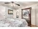 This bedroom features a mirrored armoire, ceiling fan, and a comfortable bed at 8258 E Calypso Ave, Mesa, AZ 85208