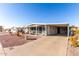 Single-story home with a covered carport, rock landscaping, and an enclosed front porch at 8258 E Calypso Ave, Mesa, AZ 85208