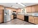 Kitchen featuring modern stainless steel appliances, wood cabinets, and a functional design at 8258 E Calypso Ave, Mesa, AZ 85208