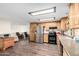 Open-concept kitchen with stainless steel appliances, wood cabinets, and seamless flow to the living area at 8258 E Calypso Ave, Mesa, AZ 85208