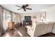 Bright living room with wood-look flooring, ceiling fan, and large windows providing ample natural light at 8258 E Calypso Ave, Mesa, AZ 85208