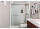 Bathroom featuring white tiled shower with glass doors and gray accent tiles at 9134 E Gary Ln, Mesa, AZ 85207