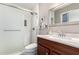 Bathroom with white tiled shower, marble countertop and cherry wood vanity at 9134 E Gary Ln, Mesa, AZ 85207