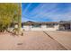 Charming single-story home featuring a desert landscape, blue shutters, and neutral exterior paint at 9134 E Gary Ln, Mesa, AZ 85207