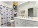 Bright bathroom featuring a double sink vanity, floral shower curtain, and lots of natural light at 9341 W Willow Bend Ln, Phoenix, AZ 85037